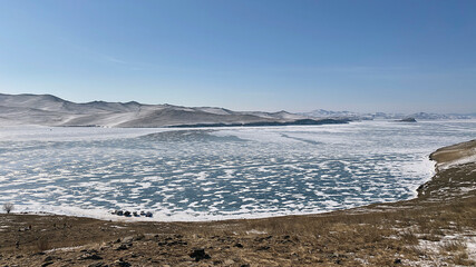 Frozen snow-capped Lake Baikal. View from above. Mountains, hills and endless expanses of Russia