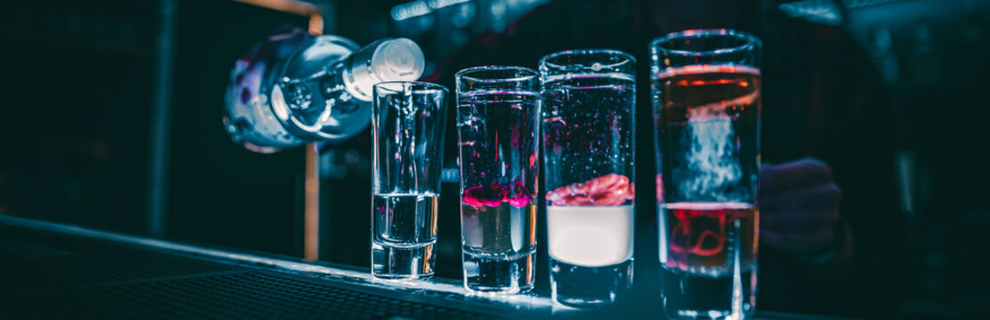 bartender making collection of colorful shots. Set of cocktails at the bar