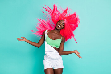 Portrait of attractive carefree cheerful girl throwing hair good mood isolated over bright blue...