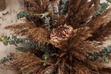 Obraz premium A table designed for a boho style event with an eucalyptus, vintage plates and other rustic touches. On seaside in the sand