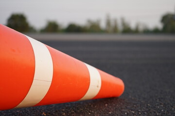 Red rubber cones are placed in the paved road.