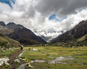 Fototapeta na wymiar Panorama landscape of people hiking in mountain range in Huaraz, Peru 