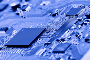 Electronic circuit board with electronic components such as chips close up. Blurry background.	
