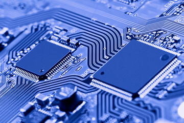 Electronic circuit board with electronic components such as chips close up. Blurry background.	