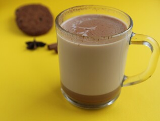 a cup of hot chocolate cocoa on a bright yellow background with room for a copyspace text