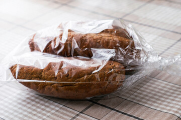 three fresh rye rolls in a plastic bag on the table