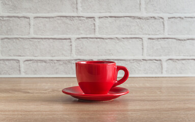 Red cup of coffee on wooden table