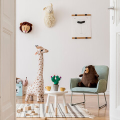 Modern and design scandinavian interior of kidroom with wooden bench, armachir, mock up poster frame, pillow, toys, teddy bear, plush toys and cute children's accessories. Stylish home decor. Template