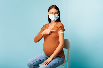 Vaccinated Pregnant Female Showing Arm After Getting Vaccine, Blue Background