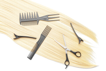 Hair strand with hairdresser's tools on white background