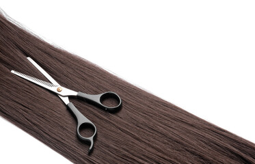 Hair strand with hairdresser's scissors on white background