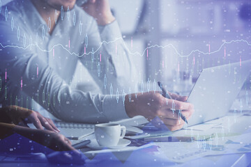 Multi exposure of man and woman working together and financial chart hologram. Business concept. Computer background.