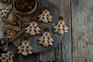 Christmas tree cookies on wooden background. New Year's food. Anise star. Festive baked goods. Gingerbread on the table.Icing sugar sweetness taste season