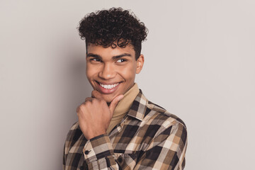 Obraz premium Photo of dreamy charming afro american man look empty space hold hand chin imagine isolated on grey color background