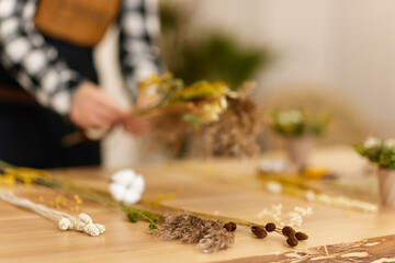 florist makes beautiful bouquet of dried flowers