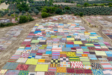 Carpet, Rugs fields. Handmade carpet color withering process in a large field area under the sun. In the hot summer season. Top view aerial drone shooting. Dosemealti, Antalya - TURKEY