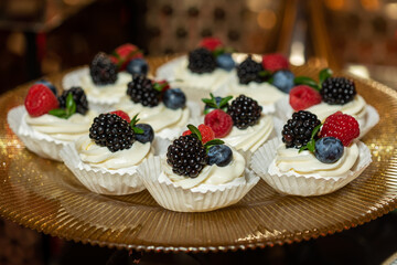 Meringue dessert with blueberries and currants on pink background