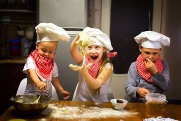 happy family fun kids baking cookies in the kitchen in chef caps selective focus