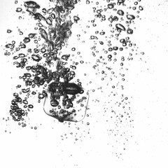 Un glaçon tombe dans un verre d'eau