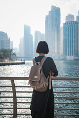 Happy young female traveler in the big city of Dubai, UAE