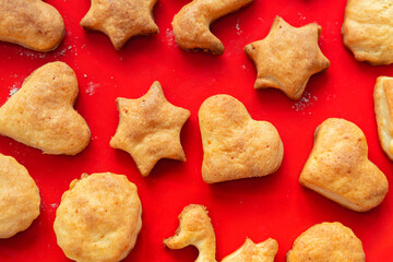 Flat lay top above view of sweet tasty delicious curd ginger cookies baked in hot oven stove on red bright silicone bakery mat at home kitchen. Homemade hot biscuits pattern background