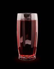 juice in a glass faceted glass isolate on a black background close-up