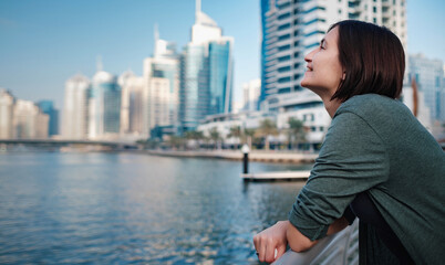 Happy young female traveler in the big city of Dubai, UAE
