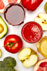 glasses of juice with sliced fruits on a white background
