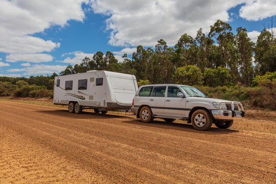 Esperance, Australia - Mar 14,2021: A large white caravan and modern 4WD vehicle park beside a unsealed gravel road near the Cape LeGrand National Park.