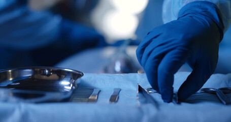 Fototapeta na wymiar Surgery instruments on surgical table with medical team and patient on blurred background.