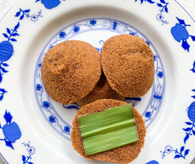 Putu Cangkir is a traditional snack from Makassar, South Sulawesi, Indonesia. Made from sticky rice, brown sugar, filled with grated coconut and covered with pandan leaves.