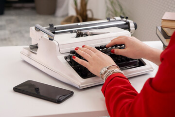  Woman Hands writing on old typewriter  im modern office .