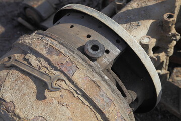 Dirty heavy truck drum brakes maintenance, old used brake pads with demounted rusty brake drum closeup