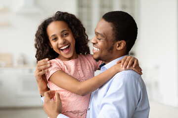 Obraz premium Happy black dad hugging with his laughing little daughter