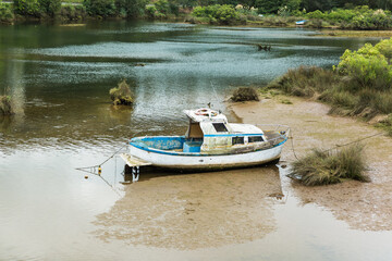 Abandoned boat moored on riverbank