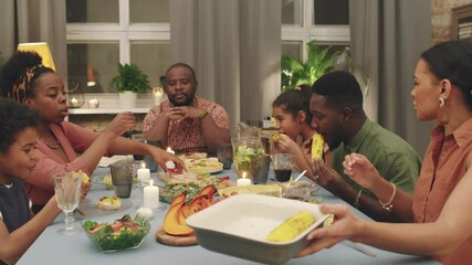 Medium PAN shot of big joyful afro-american family having dinner at home together, chatting and exchanging plates having good time celebrating special occasion - Powered by Adobe