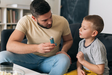 father explaining to his son how to use asthma pump