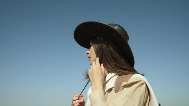 Adorable woman in cowboy hat walking near Dniester river