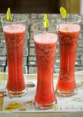 Watermelon juice served in three tall glasses.