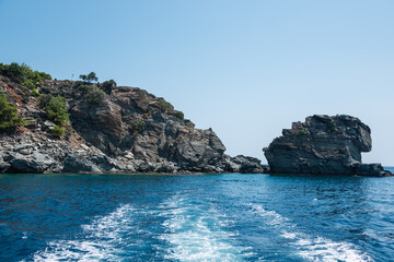 Seascape and island view with yacht trail on water surface.