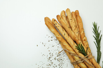 Grissini breadsticks with spices on white background