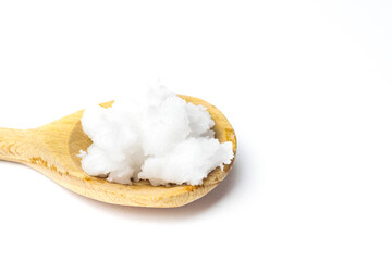 Unrefined coconut oil on a white background with wooden spoon