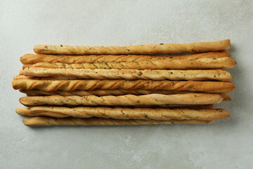 Tasty grissini breadsticks on white textured background