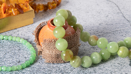 Green onyx necklace, agate  (layered chalcedony),  and jade beads on an grey natural background. ...