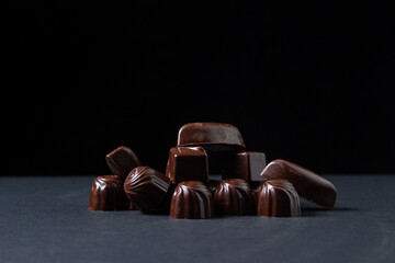 Chocolate bar on a dark background. Chocolate candies on a black background.