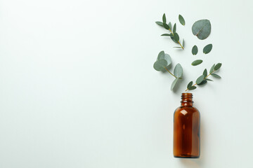 Brown bottle and eucalyptus leaves on white background