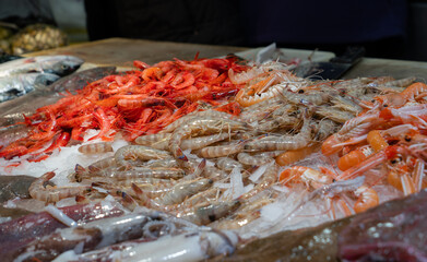 A lot of red prawns, white prawns and langoustines in a food market