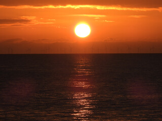 Round sun at sunrise at sea