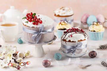 Various Spring Easter cakes eggs with white icing and sugar decor  and easter eggs on the  white table.  Easter concept