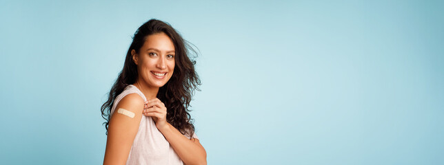 Vaccinated Woman Showing Arm After Covid-19 Vaccine Injection, Blue Background - obrazy, fototapety, plakaty